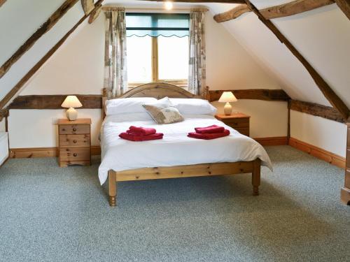 a bedroom with a bed and two lamps and a window at Butlers Barn in Darsham