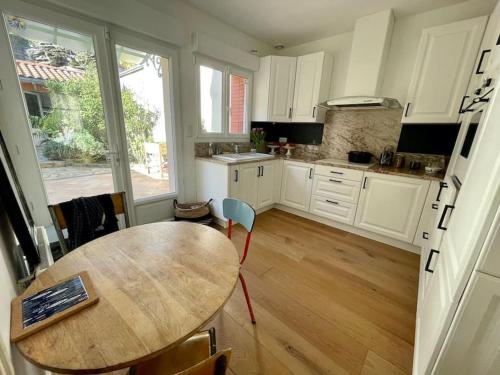 a kitchen with a wooden table and a wooden floor at Port de Pornic. Vue mer. Sea view. 4 rooms. in Pornic