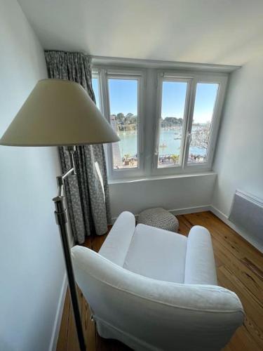 un salon avec une chaise blanche et une lampe dans l'établissement Port de Pornic. Vue mer. Sea view. 4 rooms., à Pornic