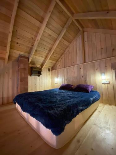 a large bed in a room with a wooden ceiling at Woodland house in Dzentsmani