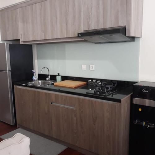 a kitchen with a sink and a stove at The Accent Apartemen in Jurangmanggu
