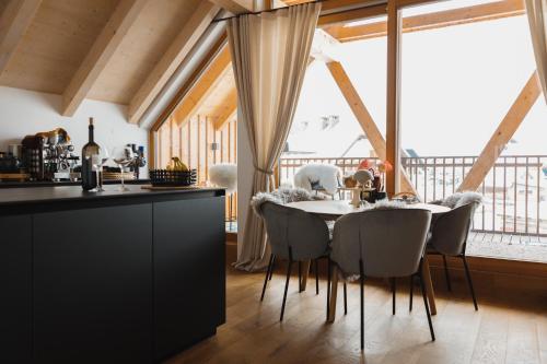 kuchnia i jadalnia ze stołem i krzesłami w obiekcie Sunny Retreat Apartment w mieście Kranjska Gora