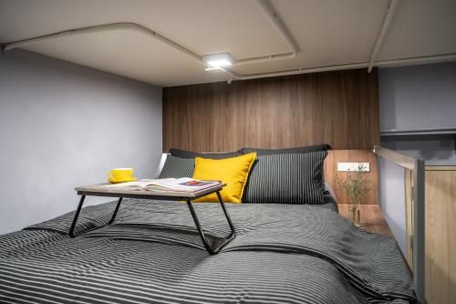 a bedroom with a bed with a table on it at C2 stay Phayathai in Pom Prap