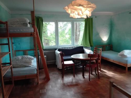 a room with bunk beds and a table and chairs at Peanuts Hostel & Meer in Surendorf