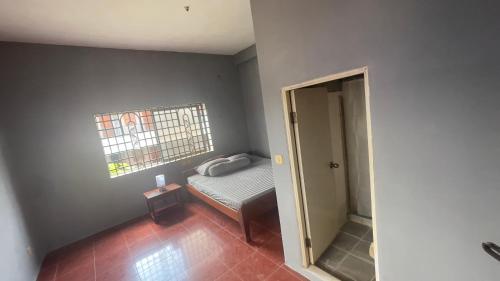 a small bedroom with a bed and a window at Siem Reap Holiday Guest House or Motel in Siem Reap
