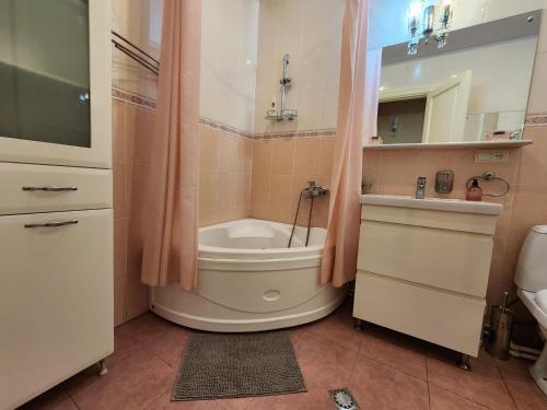 a bathroom with a tub and a toilet and a sink at Apartment at Baratashvili 10 in Tbilisi City