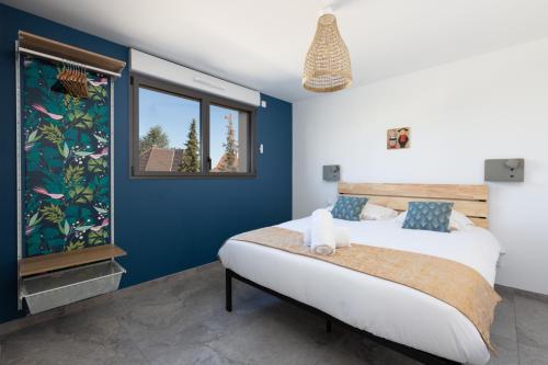 um quarto com uma cama com paredes azuis e uma janela em Villa - 230m2- 6chb - SPA-Sauna-Babyfoot-Arcade em Ittenheim