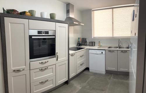 a kitchen with white cabinets and a sink at Vista Ballena in Plettenberg Bay