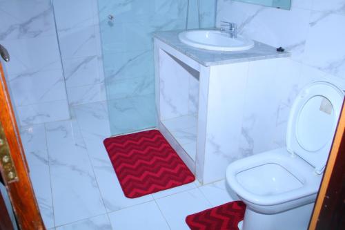 a white bathroom with a sink and a toilet at Appartement O6 à MOHAMMEDIA in Mohammedia