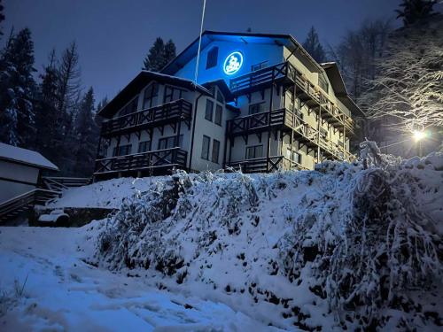 a large building in the snow at night at DACHA на Магурі in Pilipets