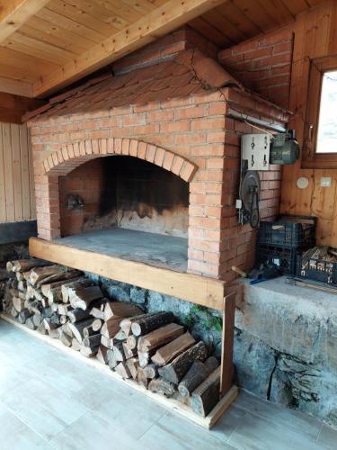 an outdoor brick oven with a table and logs at VILLA KORANA in Barilović