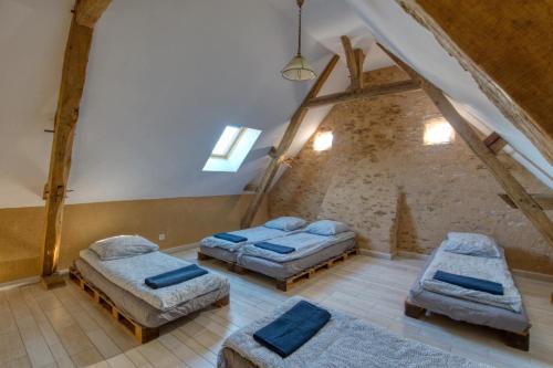 Zimmer im Dachgeschoss mit 2 Betten und blauen Kissen in der Unterkunft Crazy Villa Chateaubert 28 - Heated pool - Basket - 2h Paris - 30p in La Chapelle-Saint-Fray