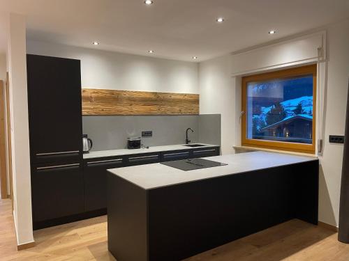 a kitchen with a black and white counter and a window at Apartments Rainer - Val Gardena in Ortisei