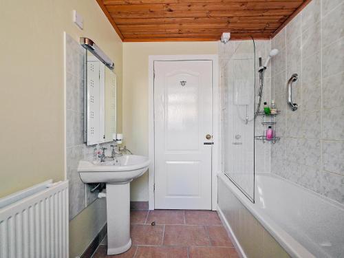 a bathroom with a sink and a shower and a tub at The Coach House in Birnam