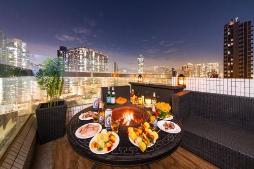 una mesa con comida en el balcón con vistas a la ciudad en O' Hotel en Hong Kong