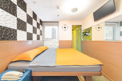 O' Hotel في هونغ كونغ: غرفة نوم مع سرير وتلفزيون على الحائط
