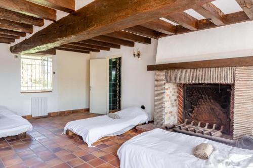 Zimmer mit 2 Betten und einem Kamin in der Unterkunft So Villa Bergerie 45 - Heated pool - Soccer - Jacuzzi - 1h30 from Paris - 30 beds in Saint-Maurice-sur-Aveyron