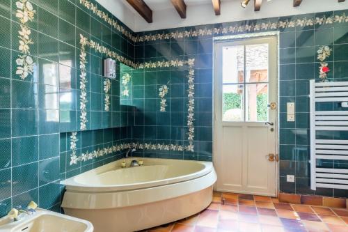 ein Bad mit einer Badewanne und einem Fenster in der Unterkunft So Villa Bergerie 45 - Heated pool - Soccer - Jacuzzi - 1h30 from Paris - 30 beds in Saint-Maurice-sur-Aveyron