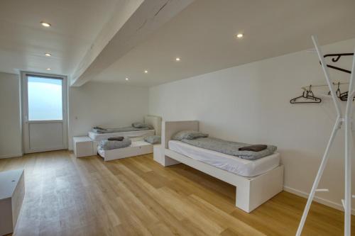 twee bedden in een kamer met een houten vloer bij Crazy Villa La Forgé Buffet 41 - Heated pool - Foot - 2h Paris - 30p in La Ville-aux-Clercs
