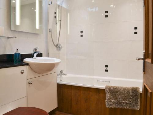 Pennacott-tns في Week Saint Mary: حمام أبيض مع حوض وحوض استحمام