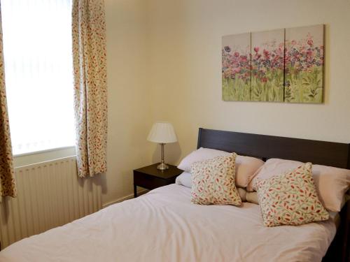 a bedroom with a bed with two pillows and a window at East Sea View in Woodhorn