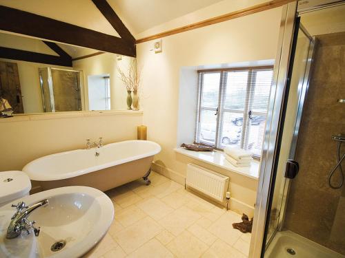 y baño con bañera y lavamanos. en Brankley Cottage - E4712, en Dunstall