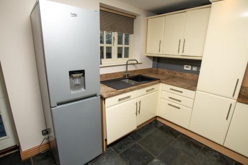 a kitchen with white cabinets and a refrigerator at Pass the Keys Family home in the countryside in Lincoln