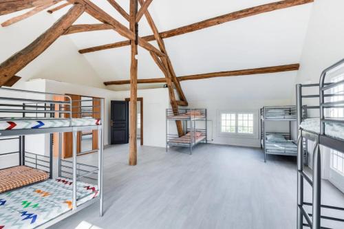 a room with bunk beds and wooden beams at Crazy Villa Etisseaux 45 - Heated pool - Volley court - 1h30 Paris - 45p in Saint-Maurice-sur-Aveyron