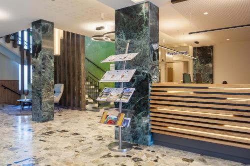 a lobby with a book display on a marble wall at Hotel-Restaurant Grimmingblick in Bad Mitterndorf