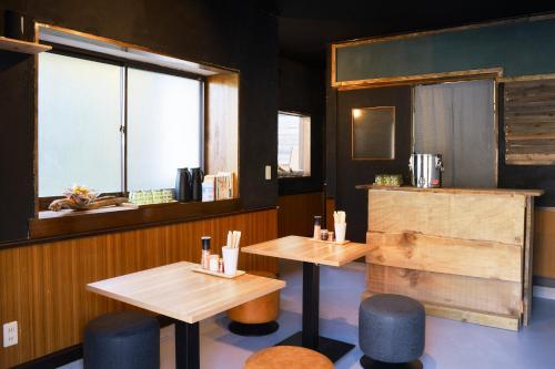 a restaurant with two tables and a window at Guesthouse Shimashima in Matsumoto
