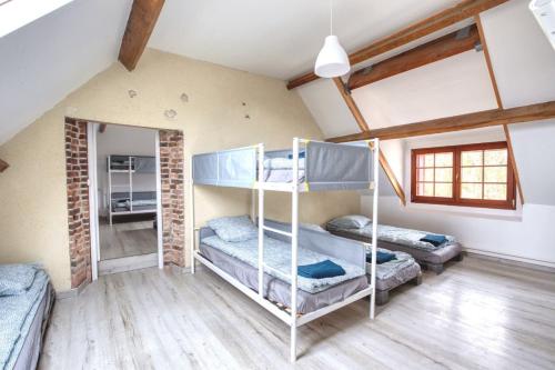 ein Schlafzimmer mit Etagenbetten im Dachgeschoss in der Unterkunft Crazy Villa Gaudiniere 89 - Heated pool - Multisport - 2h Paris - 30p in Champcevrais