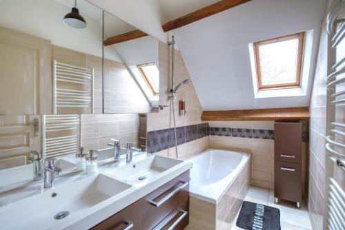ein Badezimmer mit 2 Waschbecken und einer Badewanne in der Unterkunft Crazy Villa Gaudiniere 89 - Heated pool - Multisport - 2h Paris - 30p in Champcevrais