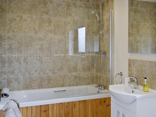 a bathroom with a bath tub and a sink at Bulrush Lodge in Burgh le Marsh