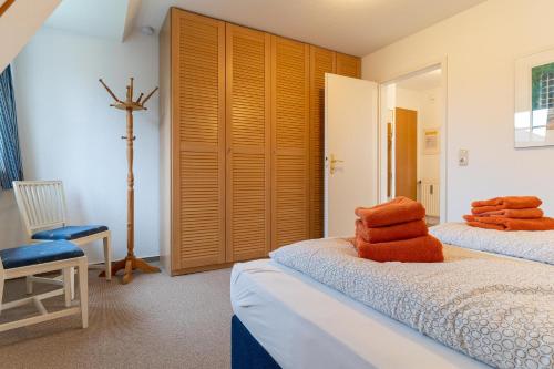a bedroom with two beds with orange towels on them at Haus-Deichsfenne-App-3-OG in Sankt Peter-Ording
