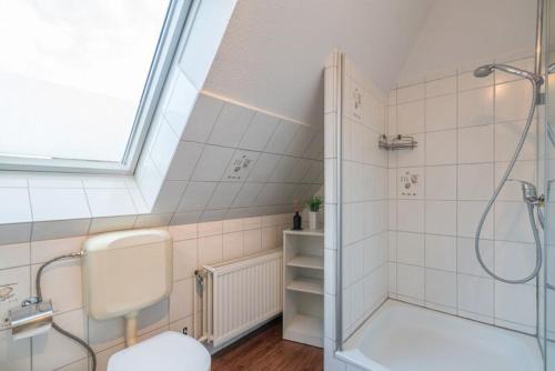 ein Bad mit einer Dusche, einem WC und einem Waschbecken in der Unterkunft Haus Angela - Appartement Tom in Sankt Peter-Ording