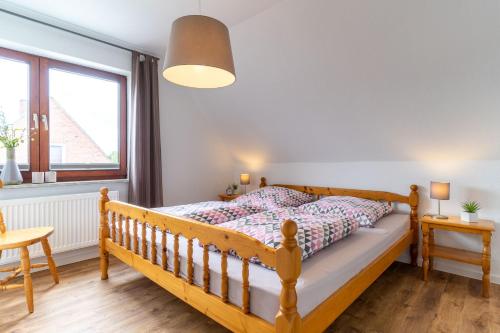 a bedroom with a wooden bed and a table at Ferienwohnung-Elli in Garding