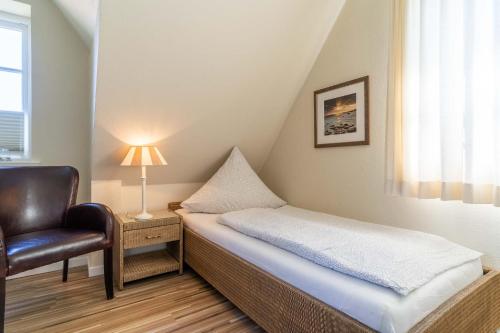 a small bedroom with a bed and a chair at Haus-Molina in Böhl