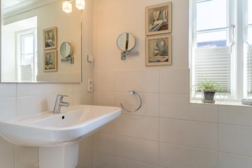 a white bathroom with a sink and a mirror at Haus-Molina in Böhl