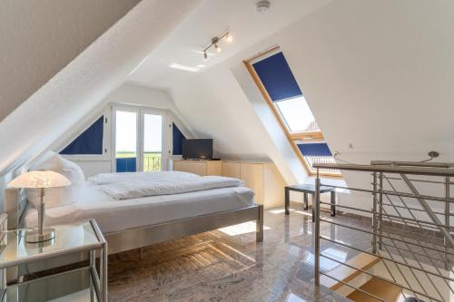 a bedroom with a bed and two large windows at Haus-Eriel-OG-links in Brösum