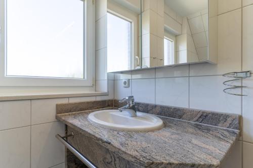 a bathroom with a sink and a mirror at Haus-Eriel-OG-links in Brösum