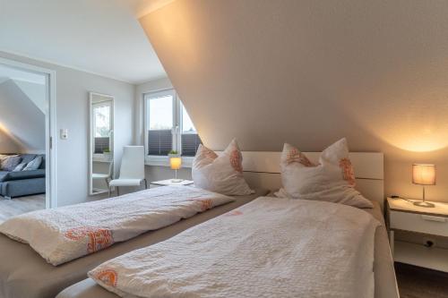 a bedroom with two beds with white sheets and pillows at Duenenzauber in Olsdorf