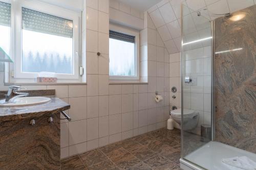 Un baño con ducha, lavabo e inodoro. en Haus-Eriel-OG-rechts, en Brösum