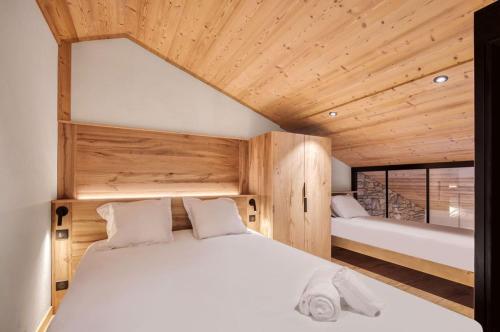 een slaapkamer met een wit bed en een houten plafond bij Appartement 123 (RDP) in Tignes