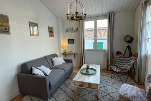 a living room with a couch and a coffee table at Very bright nest with terrace in the village in La Flotte
