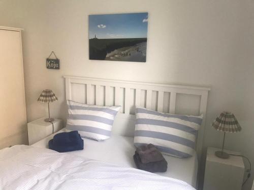 a bedroom with a white bed with blue and white pillows at Tante-Helene in Garding
