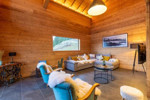 a living room with couches and a television at Chalet "Lucyvon" exceptional view in Manigod