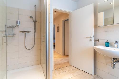 La salle de bains est pourvue d'une douche et d'un lavabo. dans l'établissement Op-de-Geest, à Böhl
