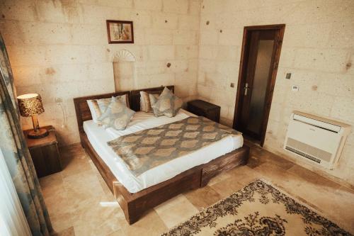 a bedroom with a bed and a lamp and a rug at Hu of Cappadocia - Special Class in Uchisar