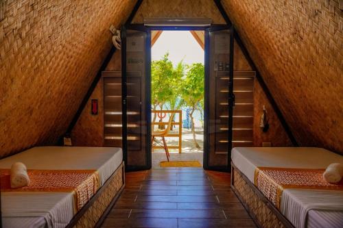 two beds in a room with an open door at Rock Island Eres Bella in Buenavista