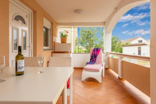 a bottle of wine sitting on a table on a balcony at Apartmani Luka in Vir